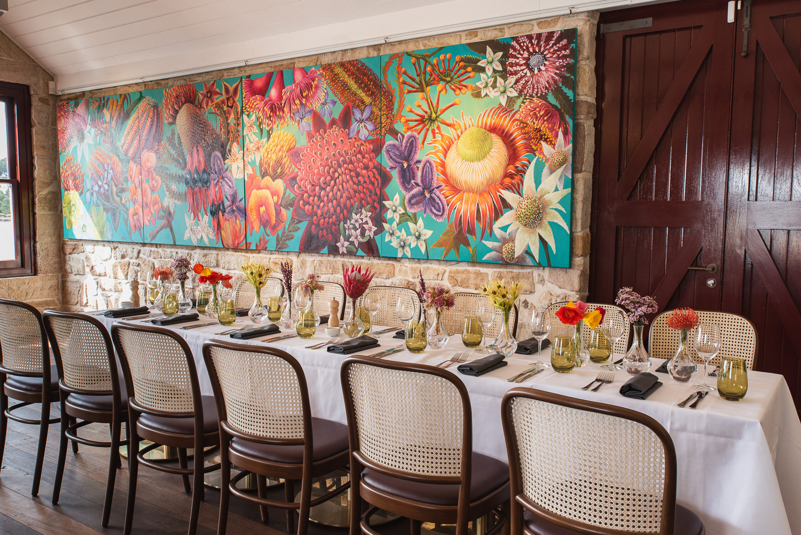Group dining table beneath colourful gallery artwork